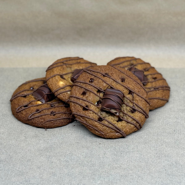 Kinder Bueno chocolate chip cookies topped with a Kinder Bueno Piece and milk chocolate drizzle.