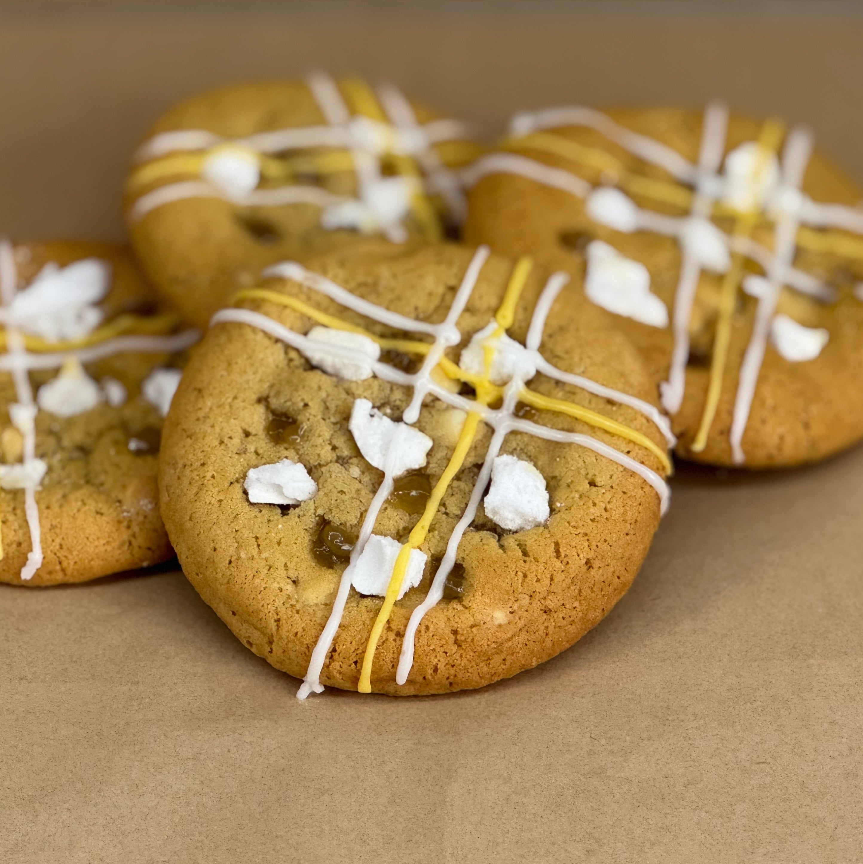 Cookies with white and yellow icing and meringue on top.